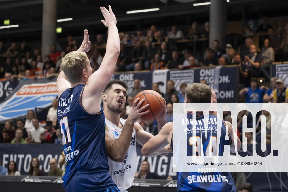 EasyCredit Basketball Bundesliga 2026–2027: Syntainics MBC vs. Rostock Seawolves, Weissenfels, Germany, October 24, 2026. Pictured, from left, in a one-on-one matchup: Bent Leuchten (Rostock), Jure Planinic (Weissenfels) and Artur Konontsuk (Rostock) at the Weissenfels Stadthalle in Weissenfels, Saxony-Anhalt, Germany
