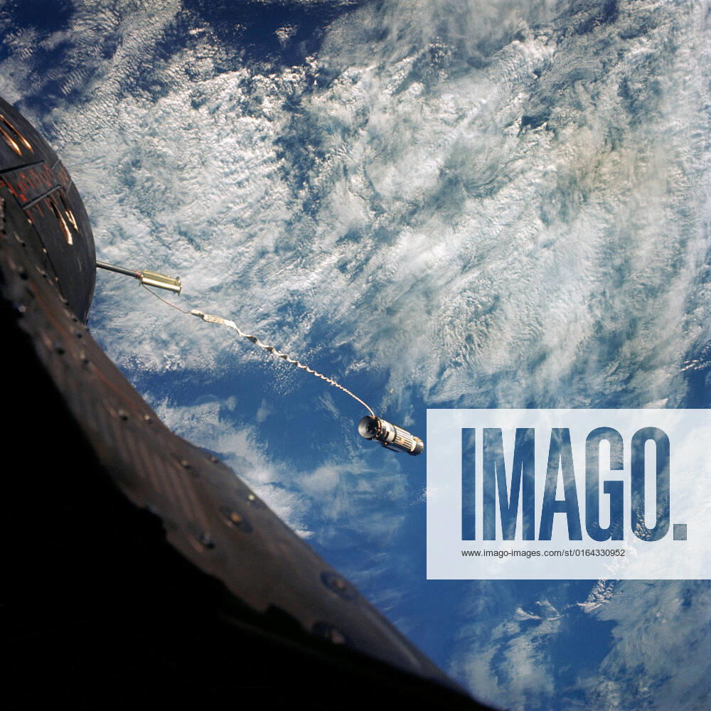 S66-62953 (13 Nov. 1966) --- A 100-foot tether line connects the Agena Target Docking Vehicle with the Gemini-12 spacecraft during its 32nd revolution of Earth. Clouds over the Pacific Ocean are in the background.