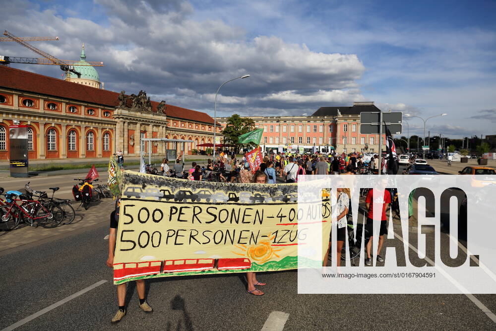 Demonstrators stand with banner 500 people 400 cars 500 people 1 train on Breite Straße as part of Students for Future bike demo Without kerosene to Berlin during a stop in Potsdam, August 31, 2022 Students for Future Without kerosene to Berlin