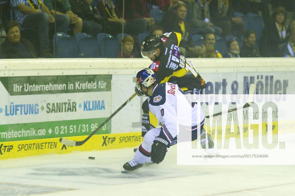 Krefeld, Deutschland 19. September 2014: 1. Bundesliga 14 15 - Krefeld Pinguine vs. EHC Red Bull Muenchen. Daniel Sparre (Muenchen) im Zweikampf gegen Adam Courchaine (Krefeld) ot