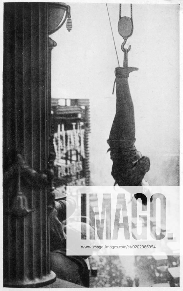 Houdini and skyscraper, New York, USA Harry Houdini (1874-1926), American stunt performer. Suspended from the cornice of a New York skyscraper, he must somehow free himself of his chains and make his way to safety ... will he do it ? Is this one trick too many? Date: circa 1920s