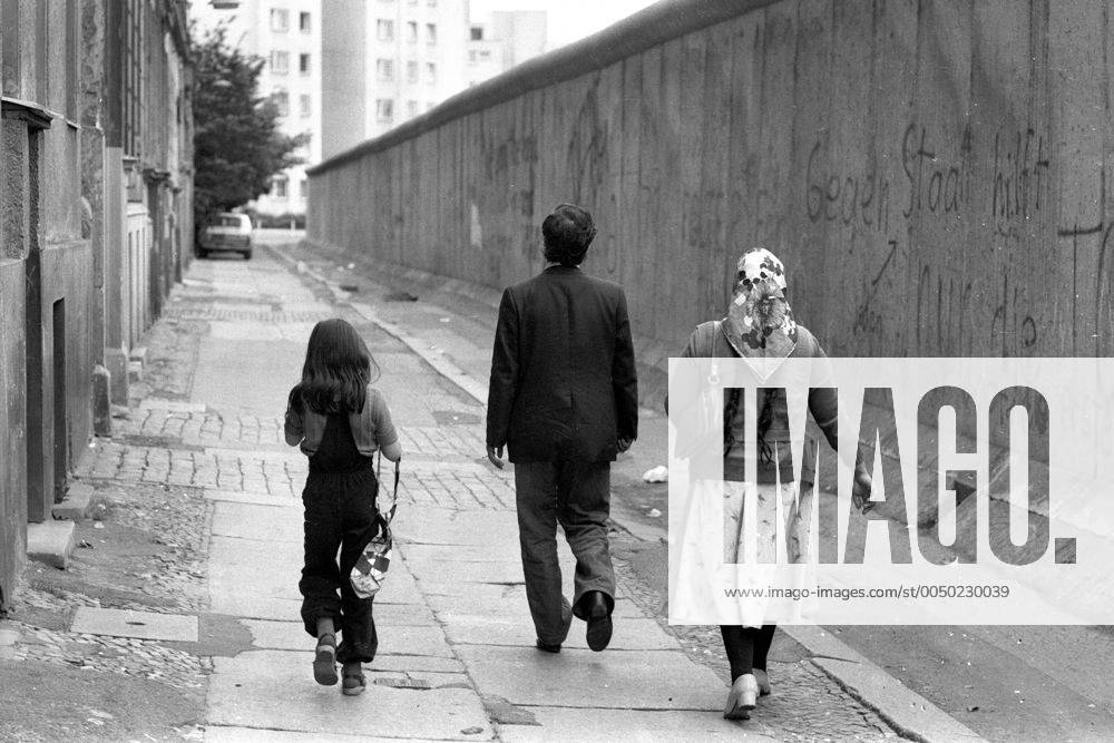 Türkische Familie geht entlang der Berliner Mauer spazieren