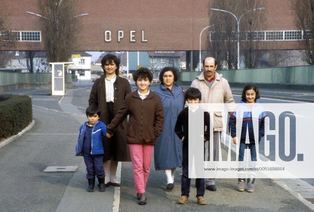 Türkische Gastarbeiterfamilie vor dem Tor der Opel-Werke in Rüsselsheim