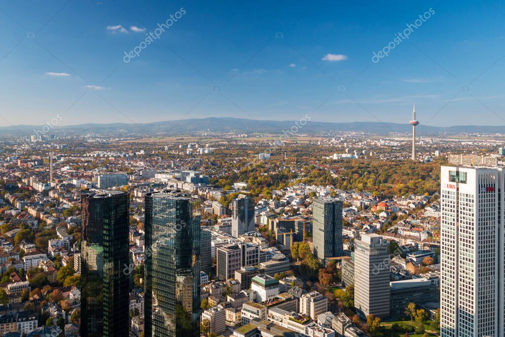 Cityscape with several bank buildings such as OpernTurm (Opera Tower), Europaturm (Tower of Europe) and Deutsche Bank Twin Towers with Taunus mountains and Feldberg in the background