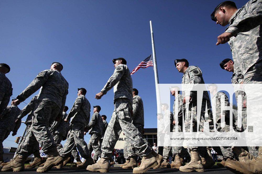 Nov. 11, 2009 - Killeen, Texas, U.S. - U.S. Army soldiers from Fort Hood Army Post walk past an American flag at half staff during the Veteran s Day Parade. Less than a week ago, a shooting rampage claimed the lives of 12 soldiers and one civilian. Fort Hood s commanding general is calling on the post to dedicate itself to the memories of those victims on this day. - ZUMAa27_