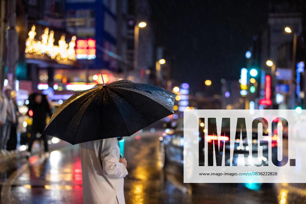 A woman with an umbrella waits at the traffic lights umbrellas during the torrential rain. Istanbul Turkey - ZUMAs197 20251003_aaa_s197_292