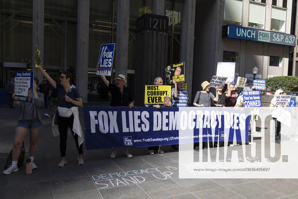 Demonstrators denouncing Fox News as extremist right-wing propaganda in support of President Trump s administration hold a banner and signs that read FOX LIES DEMOCRACY DIES MOST. CORRUPT. EVER. with an image of President Trump Rupert STOP YOUR MONSTER NO TROOPS IN OUR CITIES! FOX VIEWERS You ve been CONNED outside of News Corp s Fox News Channel in midtown Manhattan. Chalking on the plaza reads DEMOCRACY IS UNDER ATTACK STAND UP FIGHT BACK! Protesters with the activist groups Rise & Resist and Truth Tuesdays come to Fox News weekly for a peaceful demonstration calling for truth in journalism and denouncing authoritarianism, oligarchy, fascism, and Trump s agenda. New York USA - ZUMAr174 20251007_znp_r174_001
