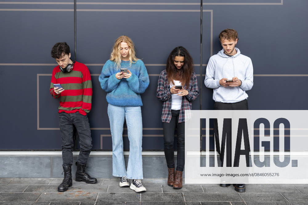 People using mobile phones outdoors in urban setting with digital addiction model released, Symbolfoto, WPEF10131