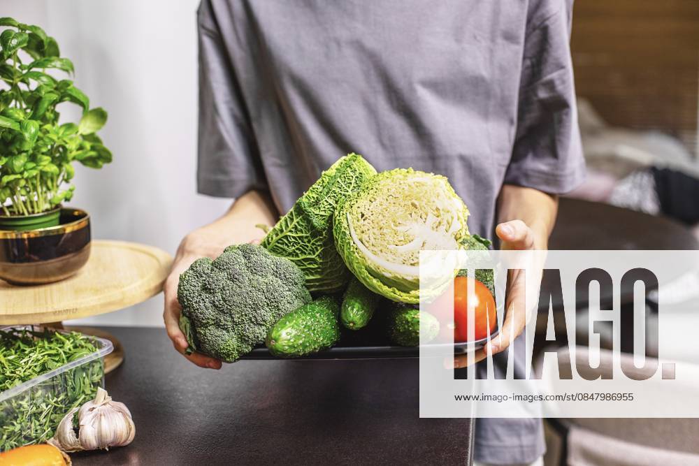 Teenager mit einer Schüssel frischem Gemüsesalat in der Küche, gesunder Lebensstil, Hausmannskost und Konzept für frische Lebensmittel teenage boy holding a bowl of fresh vegetable salad in kitchen, healthy lifestyle, home cooking and fresh food concept. (License=RF) ,model released, Symbolfoto