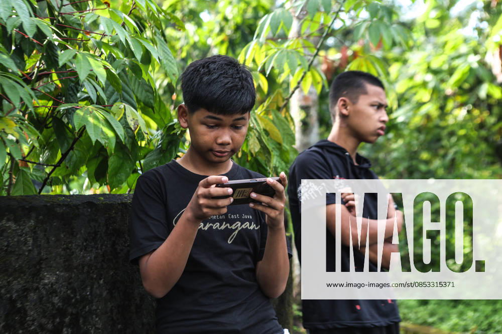 A teenager in Sleman, Yogyakarta, Indonesia, plays a game on his smartphone on Sunday, April 12, 2026. Indonesia, through the Ministry of Communication and Digital Affairs (Komdigi), has officially restricted and delayed access to social media accounts and high-risk digital platforms for children under the age of 16 starting March 28, 2026. This policy aims to protect children from pornographic content, cyberbullying, and digital addiction. Indonesia has become the first country in Southeast Asia to ban children from having accounts on YouTube, TikTok, Facebook, Instagram, Threads, X, Bigo Live, and Roblox. Sleman INDONESIA - ZUMAr184 20260412_zap_r184_005