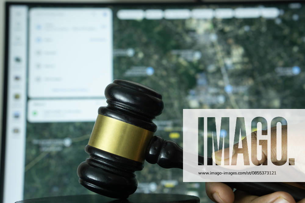 Dhaka, Bangladesch ? 20. Juni 2025: Eine Hand hält einen Hammer vor einem Computerbildschirm, auf dem die Website von Google Maps zu sehen ist Dhaka, Bangladesh- 20 June 2025: A hand holds a gavel in front of a computer screen displaying Google Maps s website (License=RM)