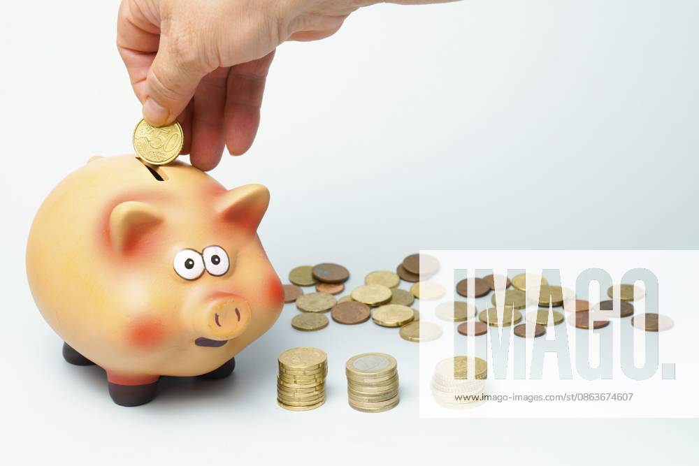Handsparende Euro Münze in einem keramischen Sparschwein, die Bankwesen, Finanzen, Investitionen und zukünftige Ersparnisse symbolisiert Hand saving euro coin in a ceramic piggy bank, symbolizing banking, finance, investment, and future savings