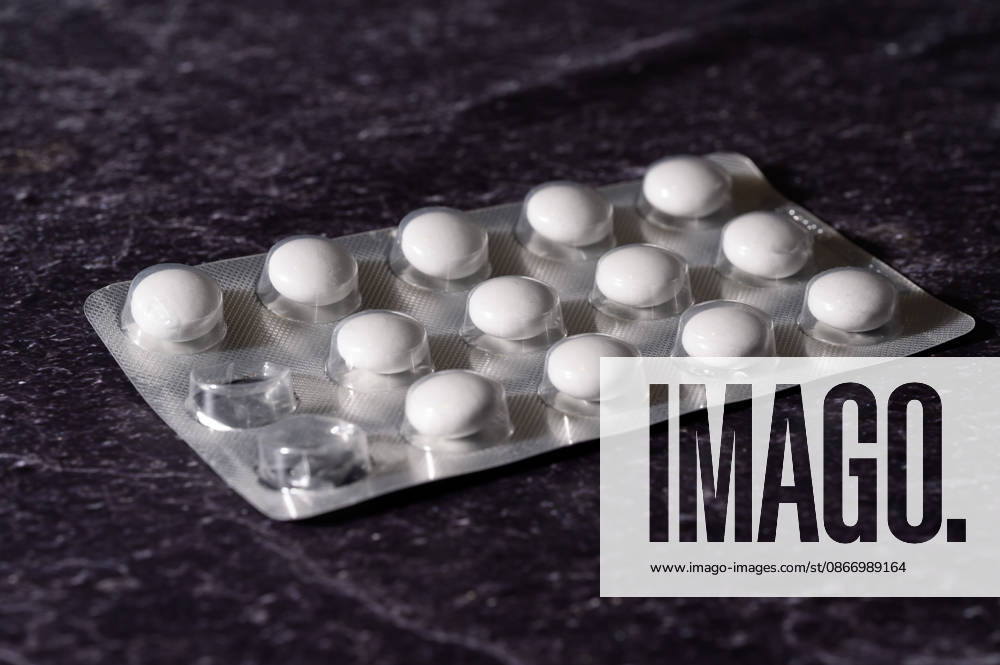 Blister pack with white tablets lying diagonally on slate, Waldsee, Germany, September 16, 2026. An opened blister pack containing white round tablets lies diagonally on a dark slate slab. Stock image representing medications and pharmacy prices.