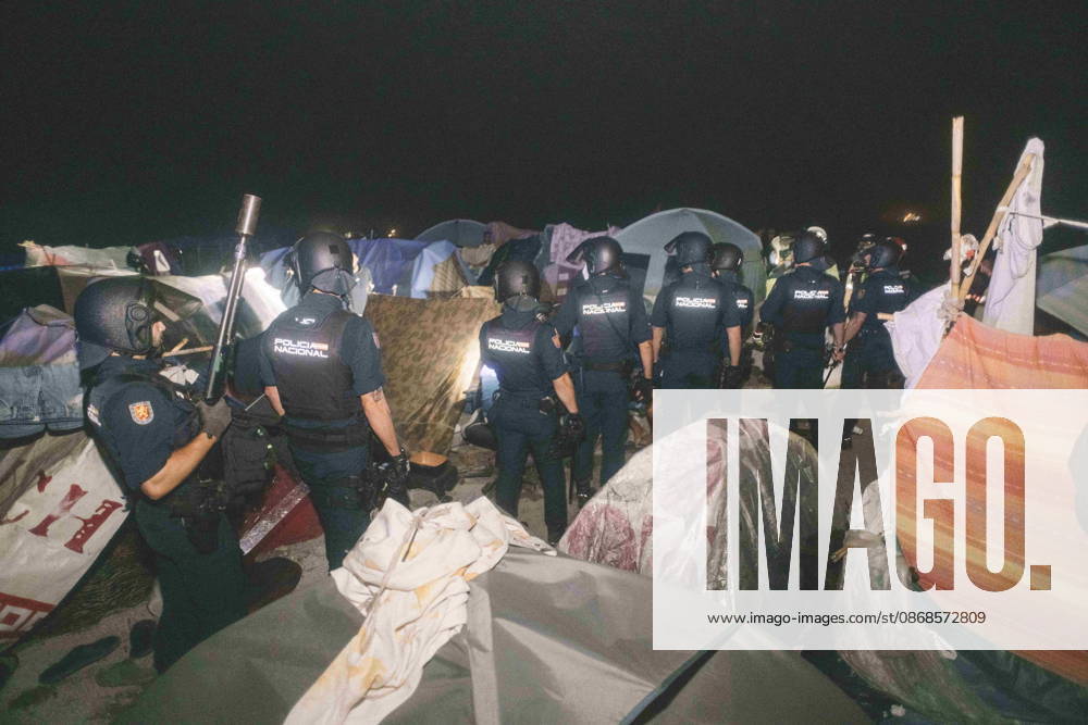 Riot police officers stand among the tents of a makeshift migrant camp in Ceuta at night. Riot police escorted firefighters through the camp on the night of October 3 to put out the fires that people living there use to cook their food. Thousands of migrants, most of them young Moroccan men, have been living in makeshift settlements in the Spanish North African enclave of Ceuta since a mass arrival at the end of July 2026 set off a migration and political crisis. Ceuta Spain - ZUMArefi 20261003_zip_s392_015