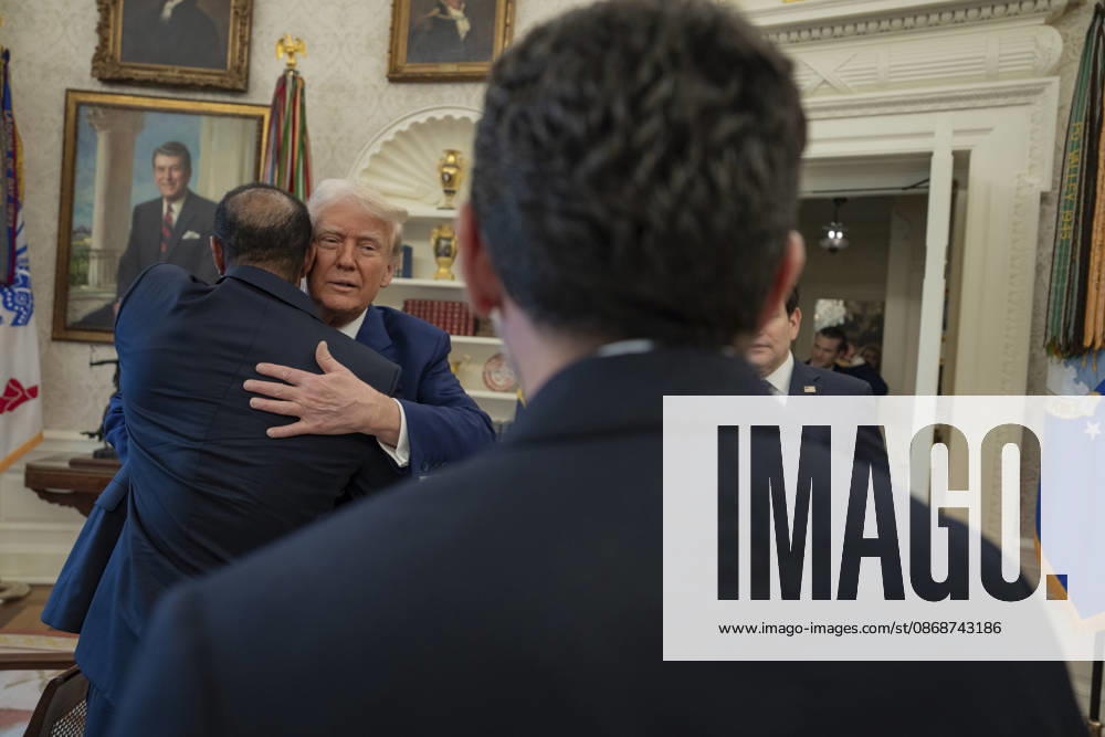 U.S. President Donald Trump embraces a guest in the Oval Office of the White House during a visit by golfer Tiger Woods, February 20, 2025 in Washington, D.C. Woods, who received the Presidential Medal of Freedom from Trump in 2019, joined PGA Tour leaders at the White House for talks on a proposed deal with Saudi Arabiaâ€⠢s Public Investment Fund before Trump introduced him as a surprise guest at a Black History Month reception. Washington United States of America - ZUMAp138 20261006_zaa_p138_023