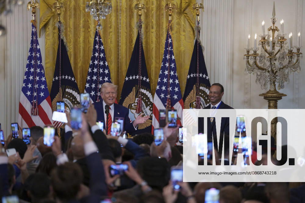 Guests raise their phones as U.S. President Donald Trump and golfer Tiger Woods appear at a reception honoring Black History Month in the East Room of the White House, February 20, 2025 in Washington, D.C. Trump introduced golfer Tiger Woods as a surprise guest at the reception in the East Room, where he praised Woods as one of the greatest athletes of all time. Washington United States of America - ZUMAp138 20261006_zaa_p138_021