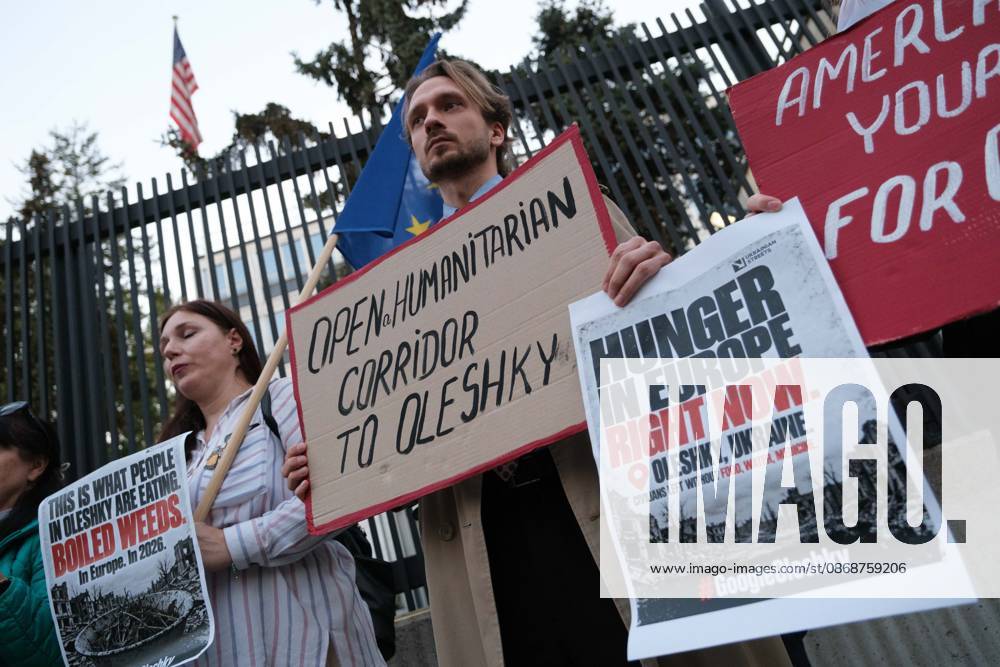 Protesters hold placards calling for humanitarian aid during a demonstration outside the US Embassy in Warsaw protesting the humanitarian crisis in Russian-occupied Oleshky. The protest was organized by Poland s Ukrainian diaspora as an appeal to Ukraine s international partners to step up diplomatic efforts to support civilians trapped in Oleshky with humanitarian aid and the possibility of evacuation. Warsaw Poland - ZUMAk204 20261006_zip_k204_002