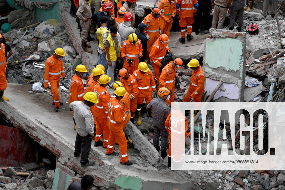 National Disaster Response Force (NDRF) jawans, Delhi Fire Service personnel, and local residents navigate heavy rubble during a search and rescue operation after a four-storey residential building collapsed in the New Seemapuri area of Shahdara on October 7, 2026, in New Delhi, India. The structural collapse occurred around 3:30 PM behind the local fish market, trapping multiple residents under concrete slabs and damaging two adjoining houses. At least one minor died while eight people were rescued and rushed to Rajiv Gandhi Super Speciality Hospital for emergency medical treatment as sniffer dogs and excavators worked late into the evening to locate remaining trapped survivors. (Photo by Ishant Chauhan Hindus