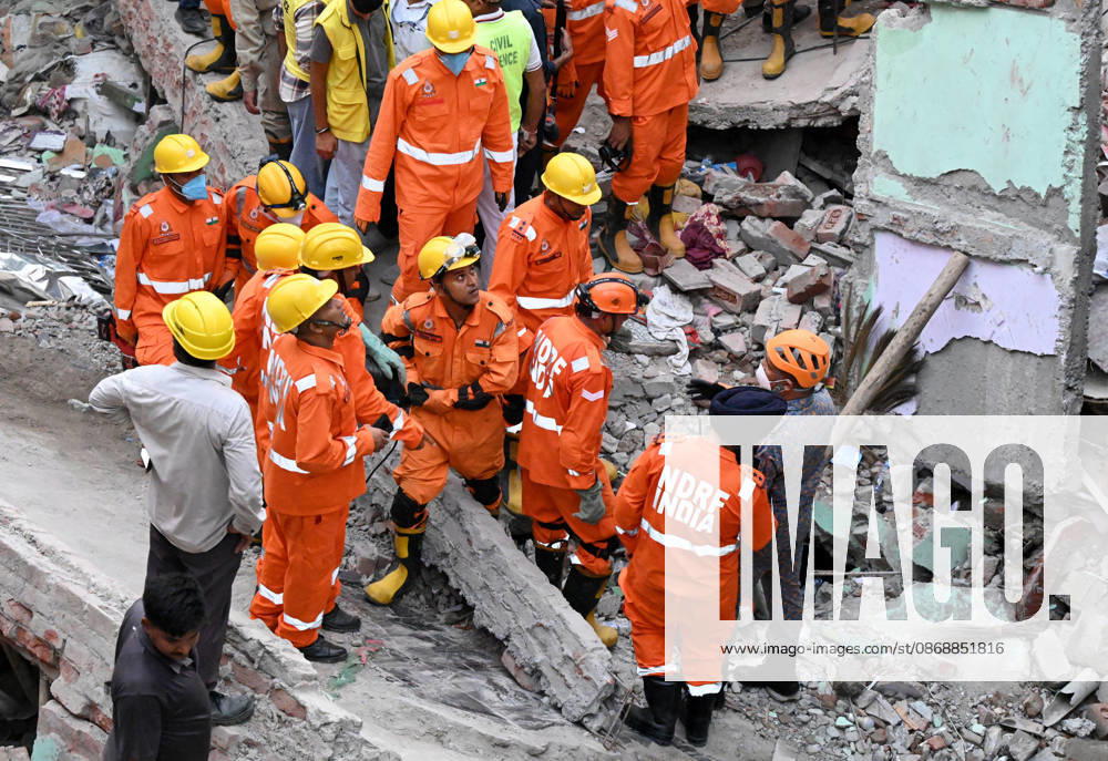 National Disaster Response Force (NDRF) jawans, Delhi Fire Service personnel, and local residents navigate heavy rubble during a search and rescue operation after a four-storey residential building collapsed in the New Seemapuri area of Shahdara on October 7, 2026, in New Delhi, India. The structural collapse occurred around 3:30 PM behind the local fish market, trapping multiple residents under concrete slabs and damaging two adjoining houses. At least one minor died while eight people were rescued and rushed to Rajiv Gandhi Super Speciality Hospital for emergency medical treatment as sniffer dogs and excavators worked late into the evening to locate remaining trapped survivors. (Photo by Ishant Chauhan Hindus