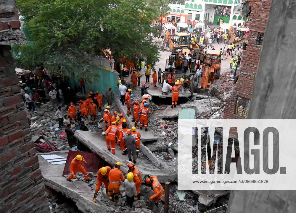National Disaster Response Force (NDRF) jawans, Delhi Fire Service personnel, and local residents navigate heavy rubble during a search and rescue operation after a four-storey residential building collapsed in the New Seemapuri area of Shahdara on October 7, 2026, in New Delhi, India. The structural collapse occurred around 3:30 PM behind the local fish market, trapping multiple residents under concrete slabs and damaging two adjoining houses. At least one minor died while eight people were rescued and rushed to Rajiv Gandhi Super Speciality Hospital for emergency medical treatment as sniffer dogs and excavators worked late into the evening to locate remaining trapped survivors. (Photo by Ishant Chauhan Hindus