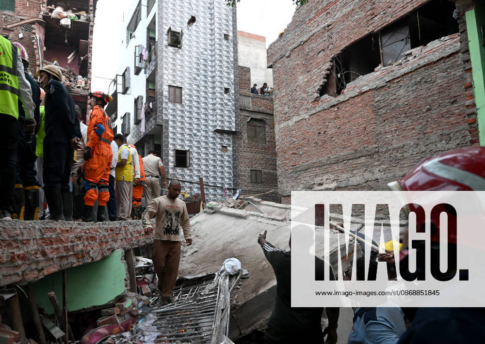 National Disaster Response Force (NDRF) jawans, Delhi Fire Service personnel, and local residents navigate heavy rubble during a search and rescue operation after a four-storey residential building collapsed in the New Seemapuri area of Shahdara on October 7, 2026, in New Delhi, India. The structural collapse occurred around 3:30 PM behind the local fish market, trapping multiple residents under concrete slabs and damaging two adjoining houses. At least one minor died while eight people were rescued and rushed to Rajiv Gandhi Super Speciality Hospital for emergency medical treatment as sniffer dogs and excavators worked late into the evening to locate remaining trapped survivors. (Photo by Ishant Chauhan Hindus