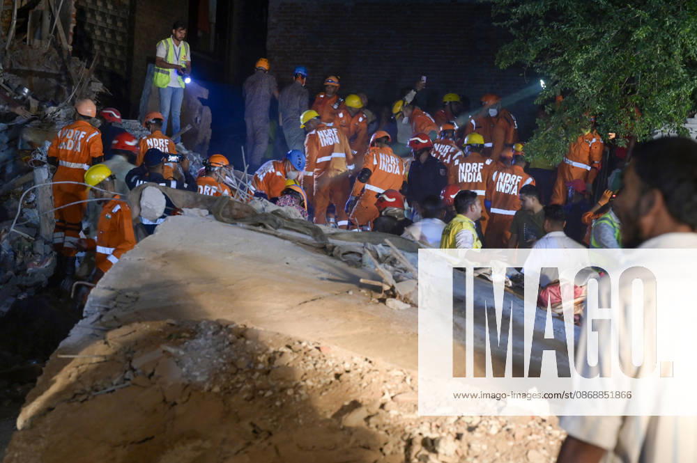 National Disaster Response Force (NDRF) jawans, Delhi Fire Service personnel, and local residents navigate heavy rubble during a search and rescue operation after a four-storey residential building collapsed in the New Seemapuri area of Shahdara on October 7, 2026, in New Delhi, India. The structural collapse occurred around 3:30 PM behind the local fish market, trapping multiple residents under concrete slabs and damaging two adjoining houses. At least one minor died while eight people were rescued and rushed to Rajiv Gandhi Super Speciality Hospital for emergency medical treatment as sniffer dogs and excavators worked late into the evening to locate remaining trapped survivors. (Photo by Raj K Raj Hindustan T