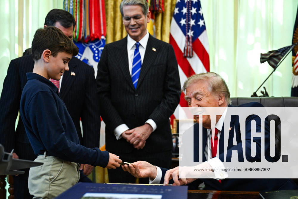 Trump Makes Oval Office Announcement WASHINGTON, DC - OCT. 7: US President Donald Trump hands a challenge coin and a pen to a child during an announcement on Trump Accounts in the Oval Office on Wednesday, Oct. 7, 2026 at the White House in Washington, D.C. (Photo by Annabelle Gordon Pool For The Washington Post) Washington DC United States