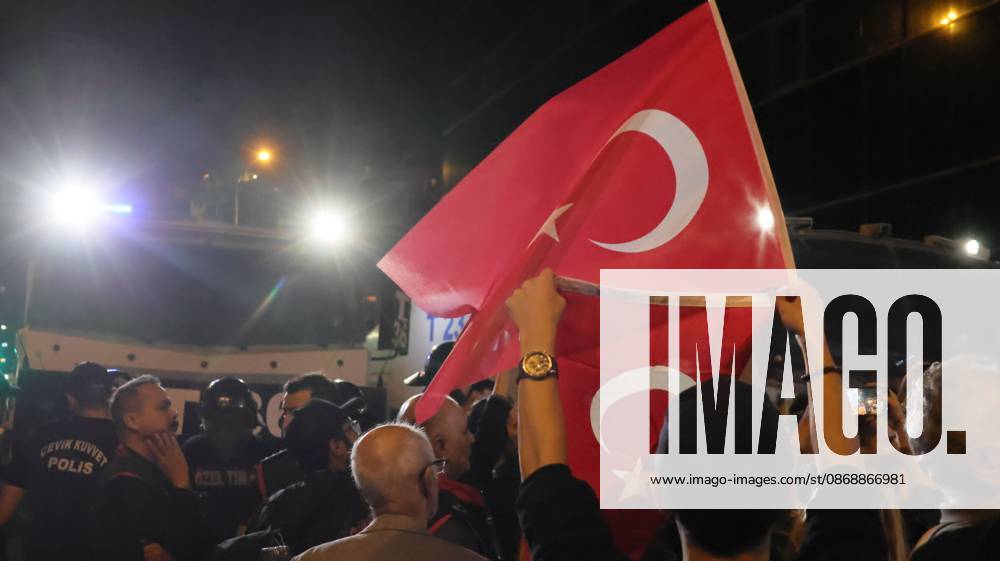 Â°Zmir, ToÂ¼rkiye: IZMIR, TURKEY, OCTOBER 7, 2026: Supporters of the opposition YENI Parti protest after Izmir Metropolitan Mayor Cemil Tugay joined President Recep Tayyip Erdogan s ruling AKP. Tugay was elected mayor as a CHP candidate in the 2024 local elections before leaving the party earlier this year. Protesters attempted to march toward Izmir City Hall carrying a black wreath, black carnations and a symbolic coffin while chanting for Tugay to resign. Police blocked parts of the march with barricades, riot police and water cannon vehicles, with protesters leaving flowers and the wreath near police barriers. Â°Zmir Türkiye - ZUMAq101 20261007_zna_q101_324