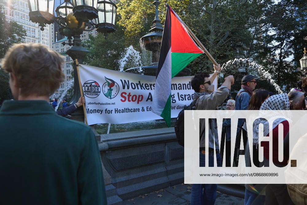 A protester holds Palestinian flags beside a banner during a pro-Palestinian demonstration at City Hall Park in New York City, New York. New York USA - ZUMAs237 20261007_aap_s237_017