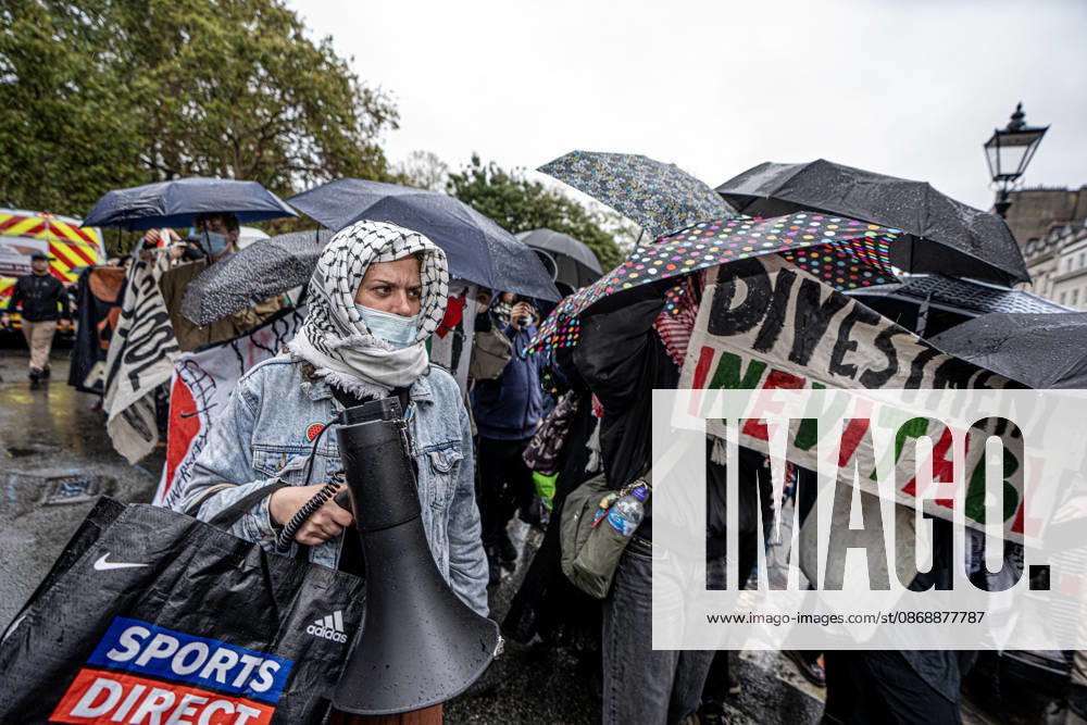 Pro-Israeil counter protestors challenge pro-Palestine demonstrators in London, UK - 7 OCT 2026. A woman seen holding a megaphone in front of pro-Palestine activists from London universities shielding themselves behind a protective wall of umbrellas while holding banners on their march . Pro-Palestine activists from Central London Universities chose the 3rd anniversary of the October 7th attack by Hamas to protest against Israel’s war on Gaza. They clashed en route with pro-Israeli counter protestors. The demonstration was arranged by an inter-uni coalition that includes King’s College and LSE. London United Kingdom