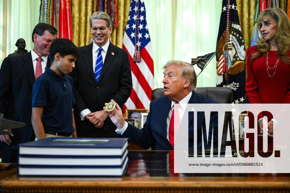 WASHINGTON, DC - OCT. 7: United States President Donald J Trump hands a challenge coin to a child during an announcement on Trump Accounts in the Oval Office of the White House in Washington, DC, USA, on Wednesday, October 7, 2026. Standing behind the President, from left to right: Frank J Bisignano, Commissioner, Social Security Administration (SSA); US Secretary of the Treasury Scott Bessent; and Susan Dell, wife of Dell Technologies CEO Michael Dell.