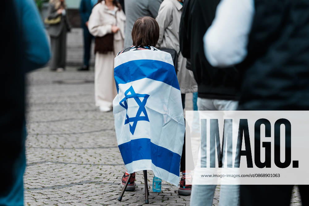 Rally in Düsseldorf marking the anniversary of Hamas s terrorist attack on Israel on October 7, 2023, and protesting anti-Semitism; woman holding a flag