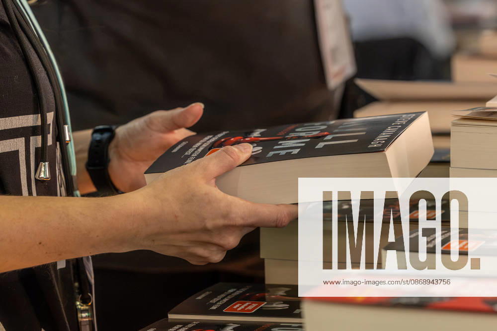 Frankfurt Book Fair 2026, August 10, 2026: A female visitor holds a book in her hand and looks at the cover. Books and visitors at the Frankfurt Book Fair 2026 on Thursday, the second day of the fair. Visitors browse th