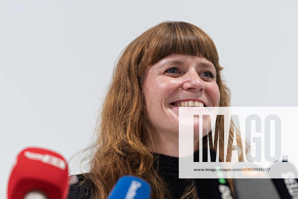Kerstin Wolter Ehling Members of Die Linke laugh during a joint press statement by Die Linke Berlin, Alliance 90 The Greens Berlin, and the SPD Berlin following the conclusion of preliminary talks in the foyer of the Haus der Statistik, behind the media microphones. Press statement by Die Linke, the Greens, and the SPD in Berlin