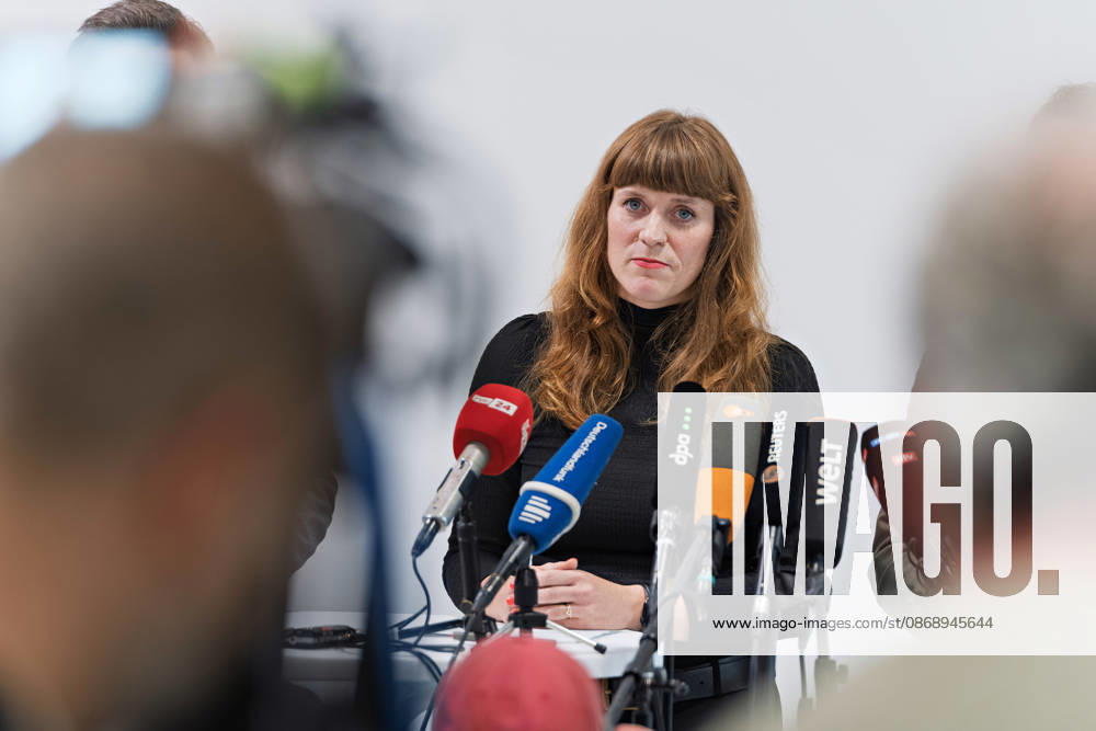 Kerstin Wolter Ehling A representative of Die Linke stands behind the microphones during a joint press statement by Die Linke Berlin, Alliance 90 The Greens Berlin, and the SPD Berlin in the foyer of the Haus der Statistik following the conclusion of preliminary talks; media representatives are in the foreground. Press statement by The Left, The Greens, and the SPD in Berlin