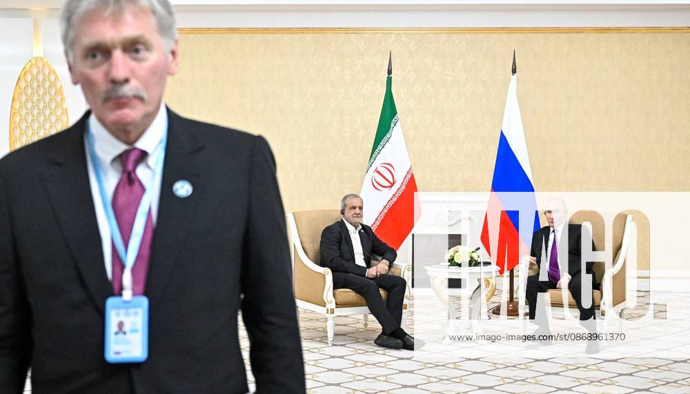 Turkmenistan Russia 9260797 08.10.2026 Iranian President Masoud Pezeshkian and Russian President Vladimir Putin attend a meeting, as Kremlin spokesman Dmitry Peskov stands nearby, in Turkmenbashi, Turkmenistan. Sergey Bobylev Sputnik Turkmenbashi Turkmenistan