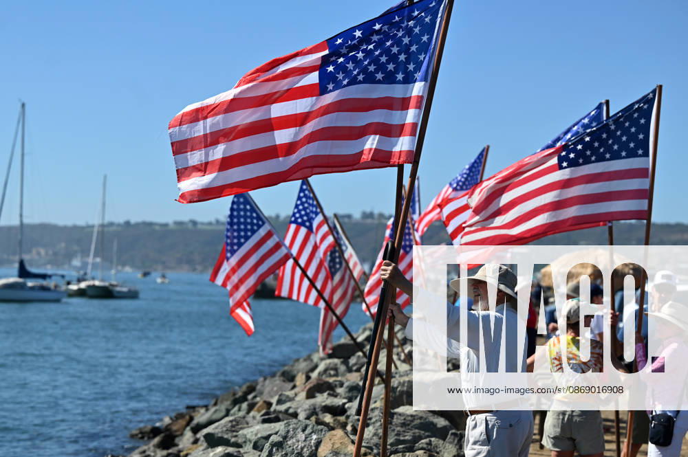 USS Abraham Lincoln returns to home port of San Diego after near-record deployment SAN DIEGO, UNITED STATES - OCTOBER 08: A man places US flags with other onlookers as the USS Abraham Lincoln Nimitz-class aircraft carrier approaches its homeport at Naval Air Station North Island on return from its historic 10-month deployment on October 8, 2026 as seen from the Port of San Diego in San Diego, California, United States. The USS Abraham Lincoln (CVN 72) set a U.S. Navy record spending over 260 days consecutively at sea without a port call while playing a key role in Operation Epic Fury and regional maritime security operations in the Middle East. Carlos A. Moreno Anadolu San Diego United States. Editorial use only. Please get in touch for a