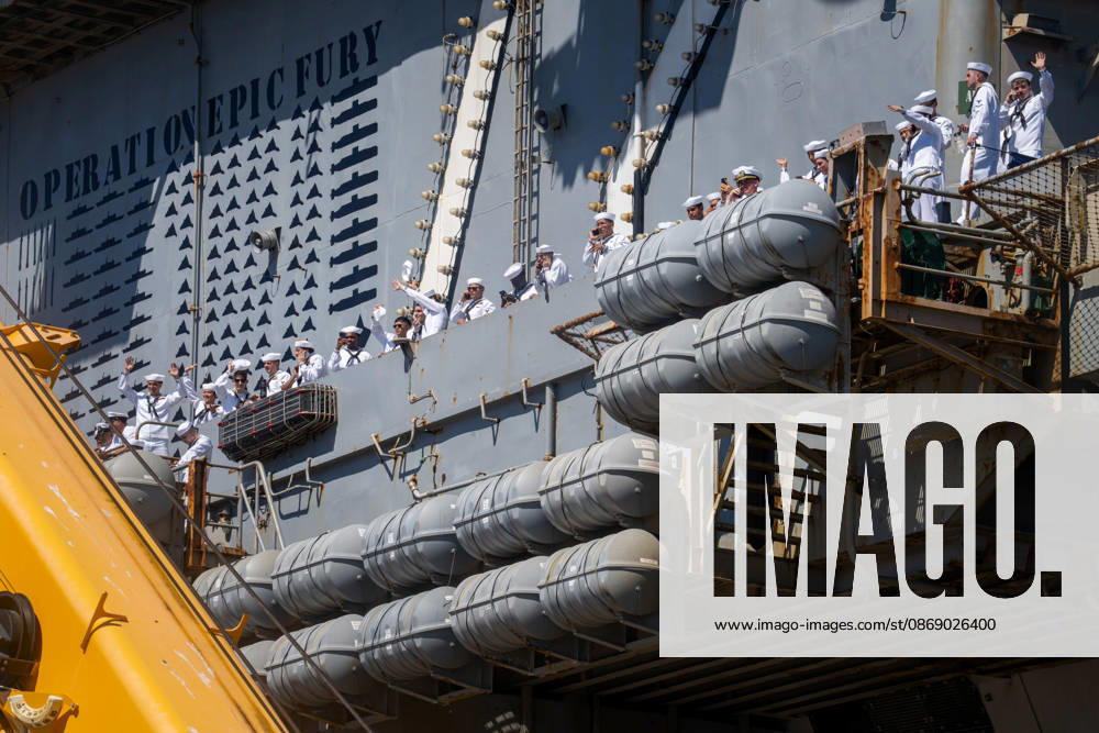U.S. Navy sailors wave from the side of the aircraft carrier USS Abraham Lincoln (CVN 72) as the ship returns to Naval Air Station North Island in Coronado, California, on October 8, 2026, following a deployment. A mural commemorating Operation Epic Fury is visible on the ship s hull. Coronado United States - ZUMAg374 20261008_znp_g374_001