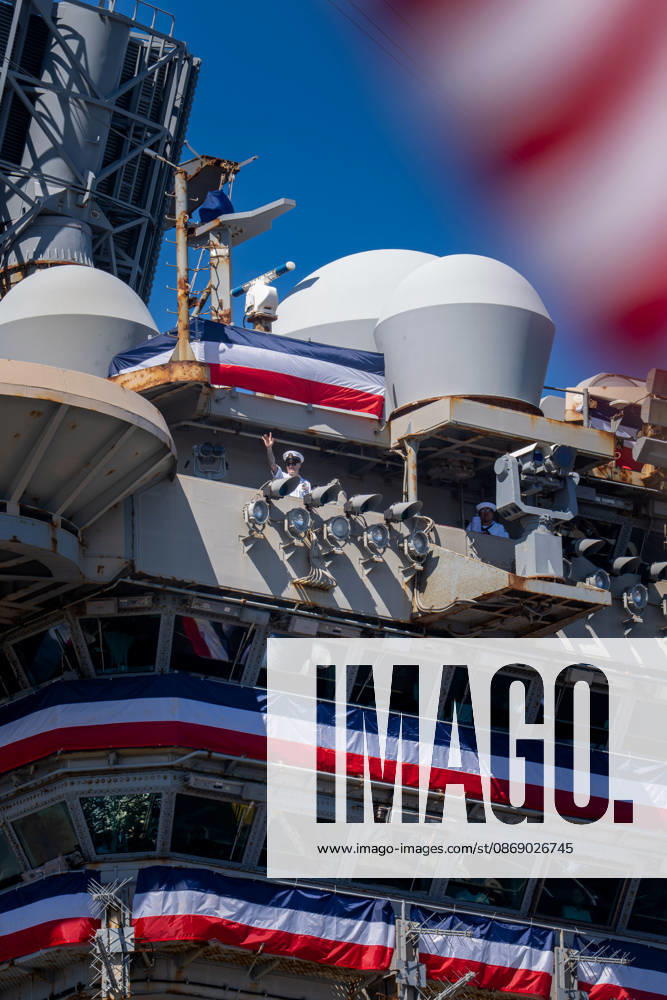 A U.S. Navy sailor waves from the island of the aircraft carrier USS Abraham Lincoln (CVN 72) as the ship returns to Naval Air Station North Island in Coronado, California, on October 8, 2026, following a deployment. Coronado United States - ZUMAg374 20261008_znp_g374_007