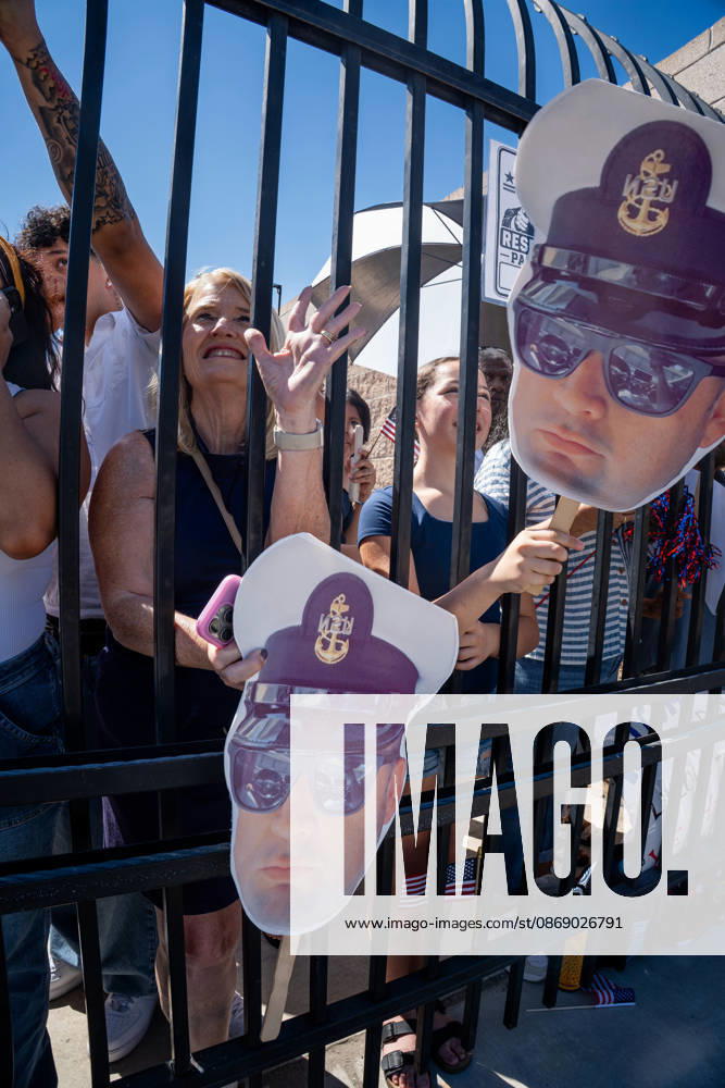 Family members and supporters wave and hold cardboard cutouts of a U.S. Navy sailor behind a fence as the aircraft carrier USS Abraham Lincoln (CVN 72) returns to Naval Air Station North Island in Coronado, California, on October 8, 2026, following a deployment. The cutouts depict a sailor wearing a Navy uniform and sunglasses. Coronado United States - ZUMAg374 20261008_znp_g374_012
