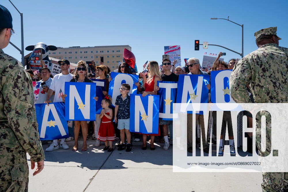 Family members and supporters hold large blue signs spelling out a sailor s name as they await the return of the aircraft carrier USS Abraham Lincoln (CVN 72) to Naval Air Station North Island in Coronado, California, on October 8, 2026, following a deployment. U.S. Navy personnel stand beside the crowd. Coronado United States - ZUMAg374 20261008_znp_g374_018