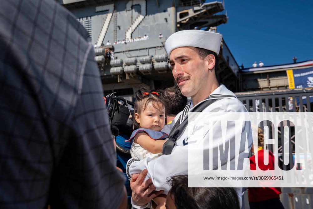 A U.S. Navy sailor holds his child for the first time during the homecoming of the USS Abraham Lincoln (CVN 72) at Naval Air Station North Island in Coronado, following the aircraft carrier s scrutinized 322-day deployment. Coronado United States - ZUMAg374 20261008_znp_g374_035
