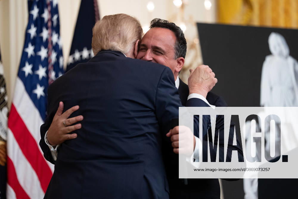President Donald Trump embraces singer Christopher Macchio during an event in the East Room of the White House in Washington, DC on Friday, Oct. 9, 2026. Trump is hosting a Columbus Day celebration. WASP20261009107 AaronxSchwartz