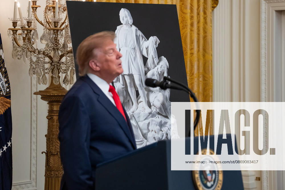 United States President Donald J Trump makes remarks in front of a poster of a statue of Christopher Columbus as he hosts a Columbus Day Celebration in the East Room of the White House in Washington, DC, USA on Friday