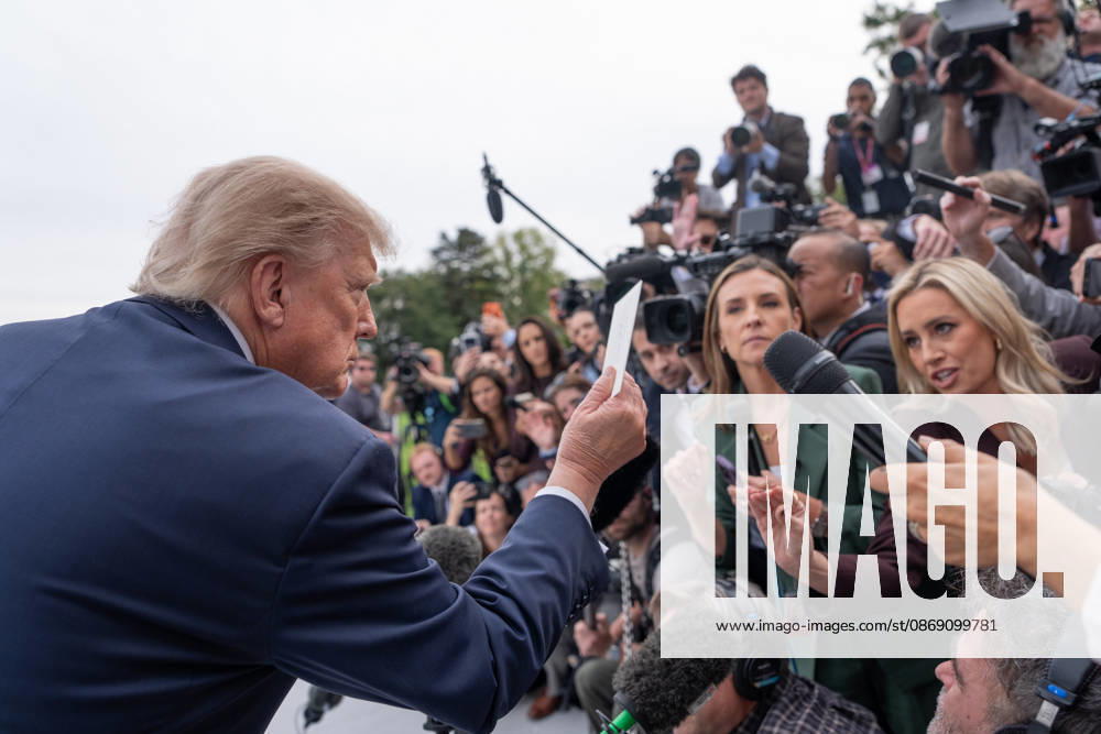 President Donald Trump is handed a note by White House Correspondent Association President Jacqui Heinrich as he speaks to members of the media on the South Lawn of the White House before boarding Marine One in Washington, DC on Friday, Oct. 9, 2026. Trump is heading to Syracuse on Friday to boost Republican gubernatorial candidate Bruce Blakeman, who is trailing Governor Kathy Hochul in polls ahead of November s election. WASP20261009144 AaronxSchwartz