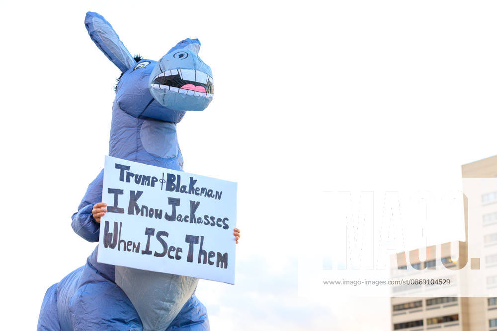A protestor holds up a sign dressed as a jackass during the protest against the Trump rally held at the Oncenter. Syracuse USA - ZUMAh195 20261009_znp_h195_001