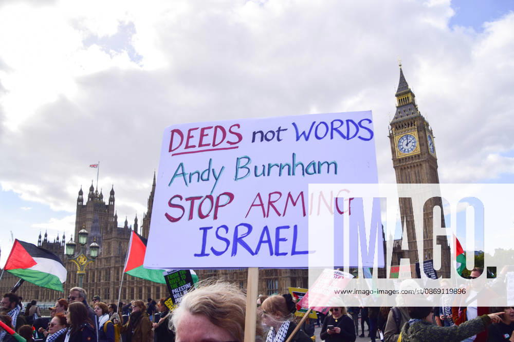 A protester on Westminster Bridge holds a sign calling on Andy Burnham to stop arming Israel as thousands of people march in support of Palestine. The protesters also called on the government to stop arming Israel and for sanctions on Israel. London United Kingdom - ZUMAv130 20261010_zip_v130_041