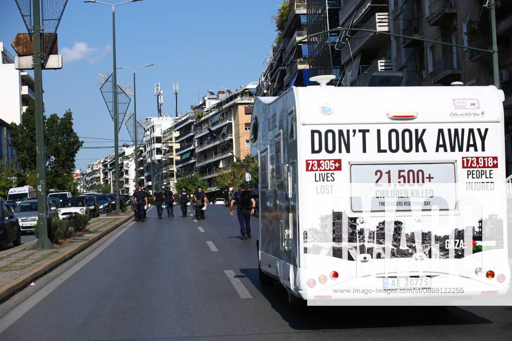 A camper van displaying messages about casualties in Gaza travels along the route of a pro-Palestinian march as riot policemen walk ahead. Athens GREECE - ZUMAx103 20261010_zip_x103_016