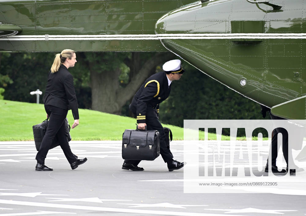 Aides carrying the briefcases referred to as the football board Marine One to accompany United States President Donald J Trump as he departs the South Lawn of the White House in Washington, DC, en route Clarksville, Tennessee on Saturday, October 10, 2026. The President will participate in a campaign rally for Tennessee Republican candidates on the ballot in November. WAX20261010201 RONxSACHS