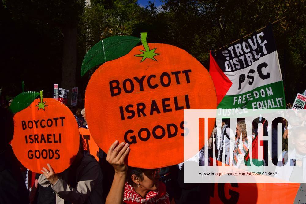 A protester holds a Boycott Israeli goods placard during the National March for Palestine..Thousands of people marched in Central London marking three years of what the protest organisers call the genocide against the Palestinian people in Gaza London United Kingdom - ZUMAs197 20261010_aaa_s197_169